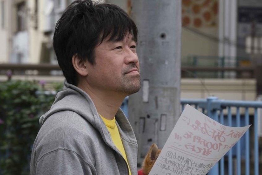 佐藤二郎 チラシ持ってる横顔